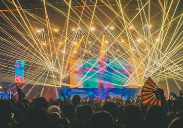 Large crowd dancing in yellow strobe lights