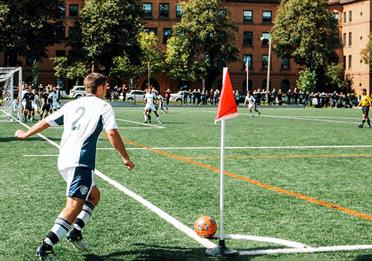 Man playing in a football match doing a corner kick