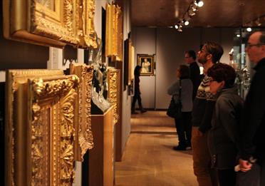 Patrons looking at art in gold frames