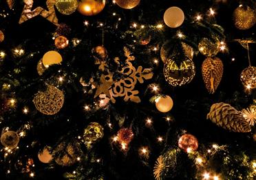 Christmas tree decorated with golden baubles and pinecones