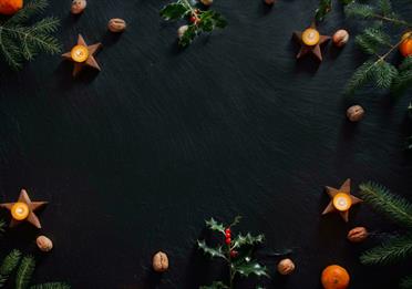 Candles and Christmas decorations on slate background