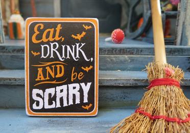 Eat drink and be scary sign with wooden broom