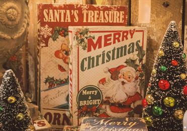 Books with Santa on the front and two tiny Christmas trees