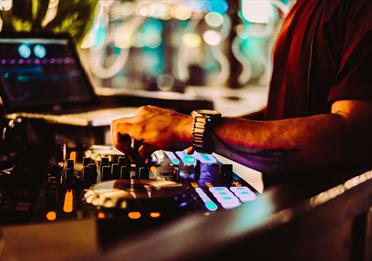 Warm toned image of a mixing desk and laptop