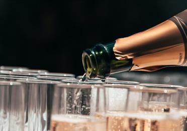 Champagne bottle pouring into glasses