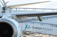Close up of aeroplane with the Exeter airport logo on the ramp to the plane