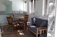 Kitchen, dining table and lounge area in Roost Apartment