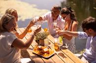 Friends enjoying food and drink outside in the sun.