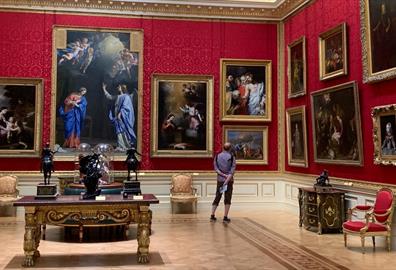 Man looking at painting in an opulent room