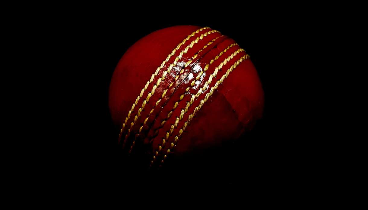Red cricket ball on dark background