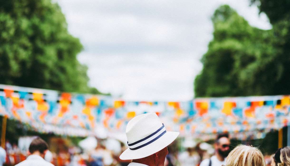 Person in white hat in front of blue and orange bunting
