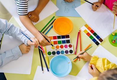 Children using pencils paint and colourful paint