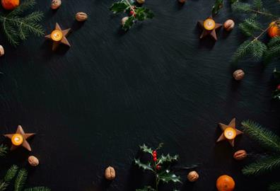 Candles and Christmas decorations on slate background