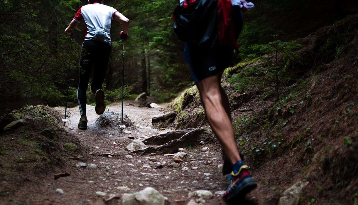 Two people running on a trail