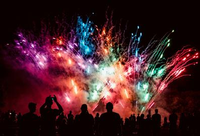 Group of people watching multicoloured fireworks