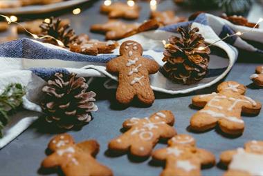 Gingerbread men surrounded with pinecones and string lights