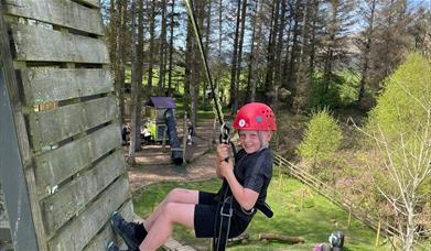 Child abseiling at The Tower Experience at Keswick Climbing Wall