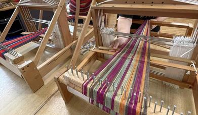 Two wooden table looms set up for weaving