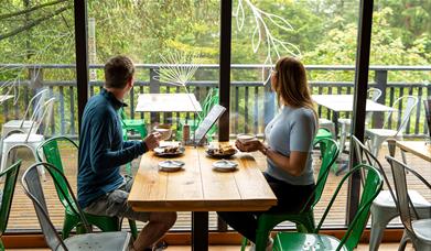 Couple enjoying lunch at at Cafe Ambio in Whinlatter Forest in the Lake District, Cumbria