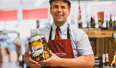 Employee with local beer at Cranstons Cumbrian Food Hall in Penrith, Cumbria