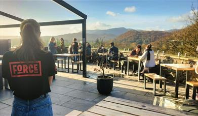 Staff member looking out over the terrace and mountain views at Force Cafe Ambleside in the Lake District, Cumbria