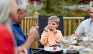 Family Enjoying a Meal at a Gatebeck Holiday Park Holiday Home in Gatebeck, Cumbria