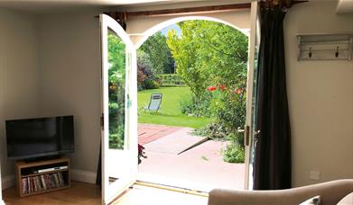 Double doors leading to the garden and outdoor seating at The Cottage at Linden Farm House in Langwathby, Cumbria