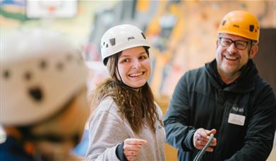 Visitors rock climbing indoors with Lake District Calvert Trust
