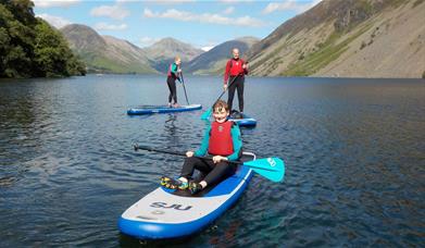 Visitors Paddleboarding in the Lake District with Path to Adventure