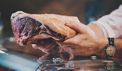 Butcher working at Tebay Services Farmshop and Kitchen in Tebay, Cumbria