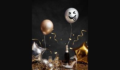 Celebration meal with balloons, high heels and champaign