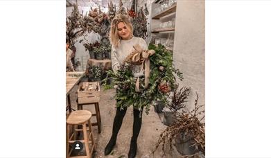 A girl holding a Christmas wreath