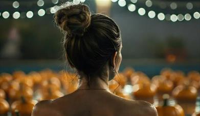 women looking over a pumpkin patch at night