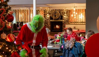Photo of the Grinch at The Swan Hotel & Spa looking at a Christmas tree