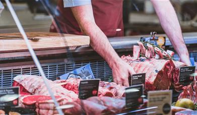 Chris Russell with beef at the butchers counter at Cranstons Orton Grange Food Hall near Carlisle, Cumbria
