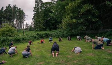photo of people laying down in a circle in a field