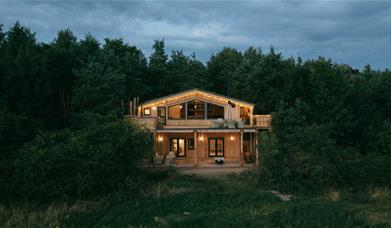 Exterior of Luna Treehouse at Into the Woods at nighttime near Little Salkeld, Cumbria