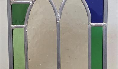 a person holding up a stained glass window