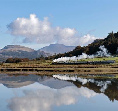 Ravenglass and Eskdale Railway Train with a scenic mountain backdrop and lake reflection © Mark Fielding