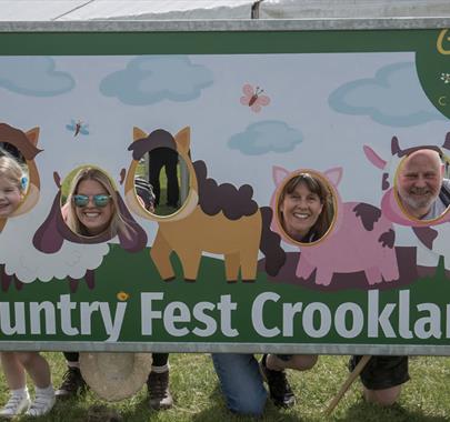 Visitors pose at a photo board at Country Fest in Crooklands, Cumbria