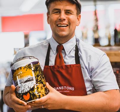 Employee with local beer at Cranstons Cumbrian Food Hall in Penrith, Cumbria
