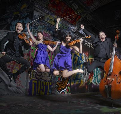 Graffiti Classics band jumping with their instruments 
