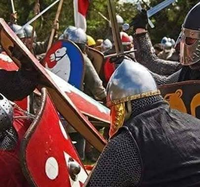Medieval reenactment battle, two armies fighting each other with swords and shields.