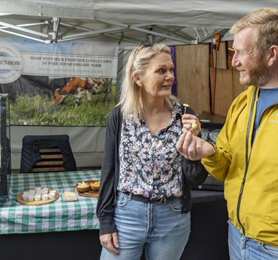 Visitors at a Stall at Keswick Saturday Market in the Lake District, Cumbria