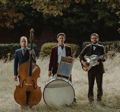 Photo of "Leeds City Stompers" standing in a field with their respective instruments