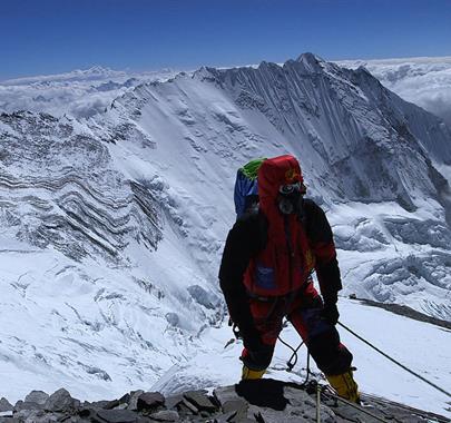 Keith Partridge climbing a snowy mountaintop above the clouds