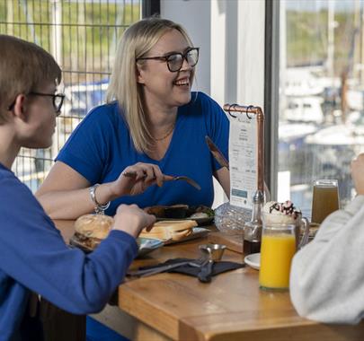 Family having food & drink at Marina View Cafe in Maryport, Cumbria