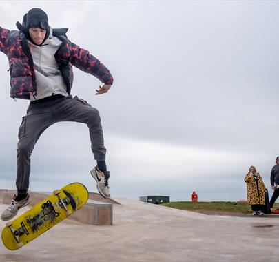 Visitor doing skateboard tricks at Maryport Skate Park in Maryport, Cumbria