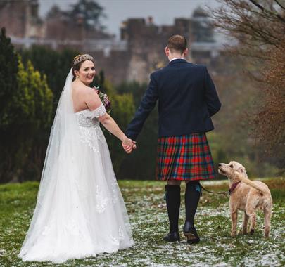 Bride and Groom Posing with Scenery at Muncaster Castle in Ravenglass, Lake District