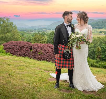 Bride and Groom Posing with Scenery at Muncaster Castle in Ravenglass, Lake District